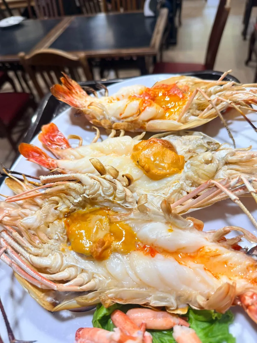 Large river prawns split lengthways and grilled, the orange roe left in the heads.